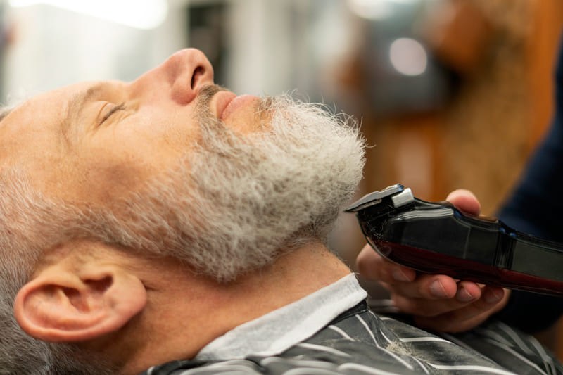 Man about to have a razor shave by a barber