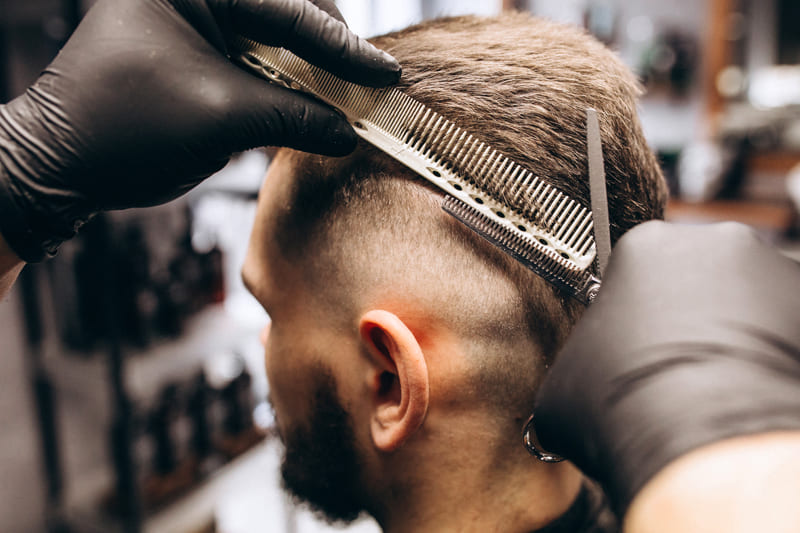 client having haircut at the barber shop salon